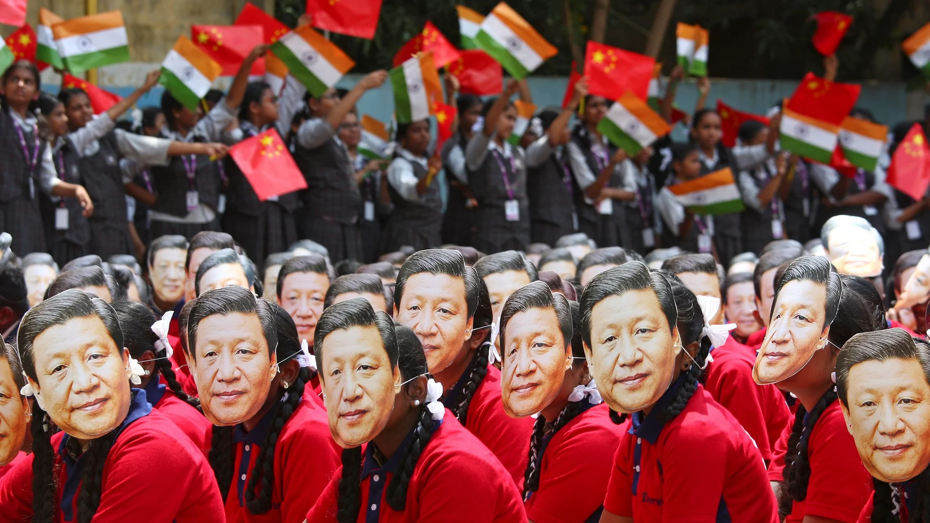 FILE PHOTO: Students wear masks of China's President Xi Jinping as other waves national flags of India and China, ahead of the informal summit with India?s Prime Minister Narendra Modi, at a school in Chennai