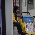 Una trabajadora de correos en una parada de autobús. María José López / Europa Press