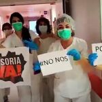 Imagen de un grupo de sanitarios con carteles que muestran su determinación por acabar con la pandemia