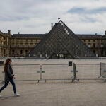 Una mujer pasea por el Louvre