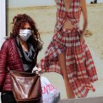 Una mujer pasea con mascarilla por las calles de Sevilla