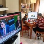 La granadina María Ruiz, como cada mañana, mira las noticias digitales en el ordenador y en la televisión