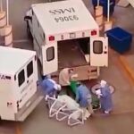 Momento en el que el paciente yace tirado en el suelo y los sanitarios tratan de devolverle a la camilla para subirlo a la ambulancia