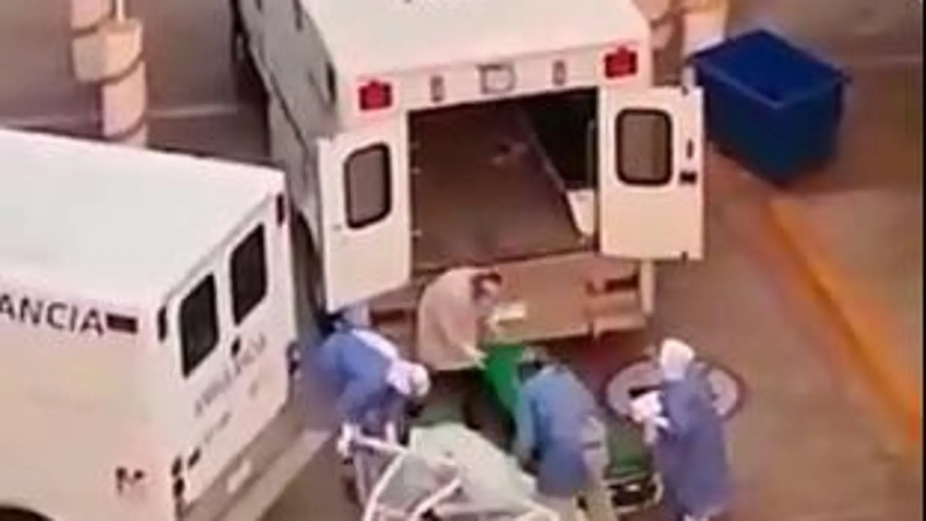 Momento en el que el paciente yace tirado en el suelo y los sanitarios tratan de devolverle a la camilla para subirlo a la ambulancia
