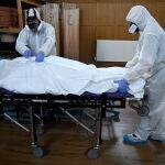 Trabajadores de una funeraria trasladan a un fallecido por Covid-19 en Londres