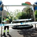 Un operario precinta un columpio en Valencia.