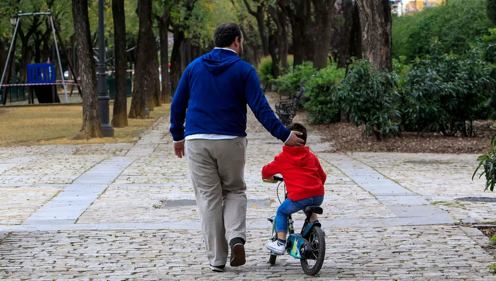 Un padre acompaña a su hijo en un parque sevillano