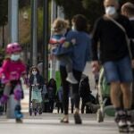 Familias con niños paseando hoy por una calle de Barcelona