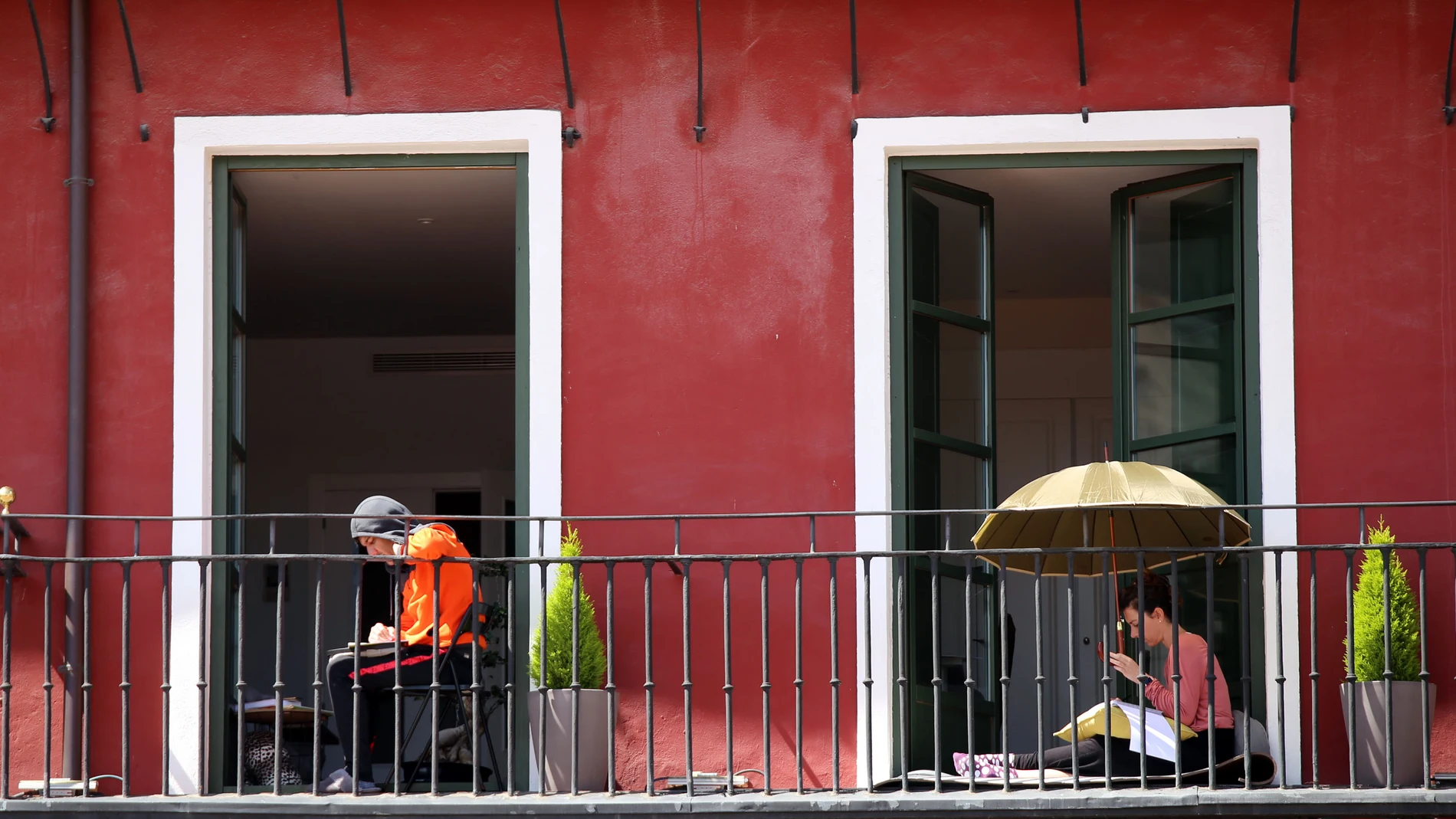 Dos personas toman el sol en el balcón de su vivienda en la Plaza Mayor de Valladolid