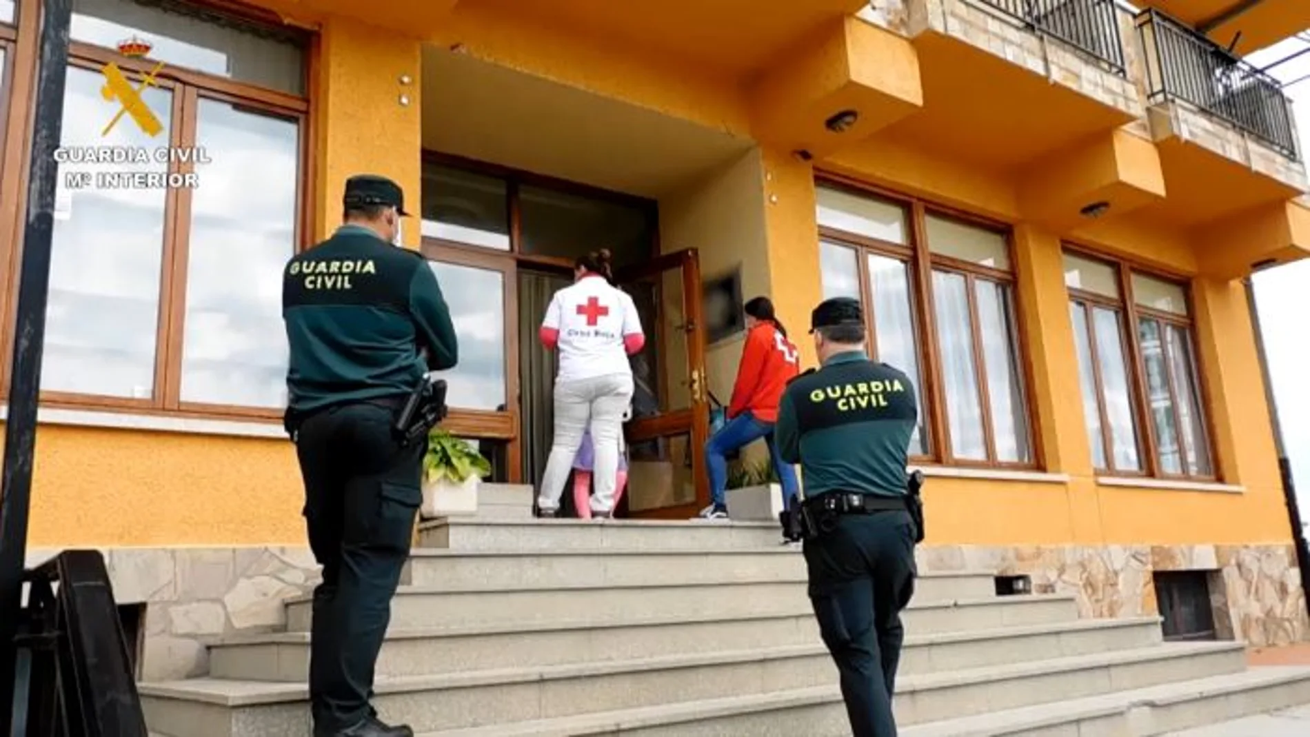 Dos trabajadoras de Cruz Roja Zamora dialogan con las mujeres a las puertas del club de alterne, escoltadas por miembros de la Guardia Civil