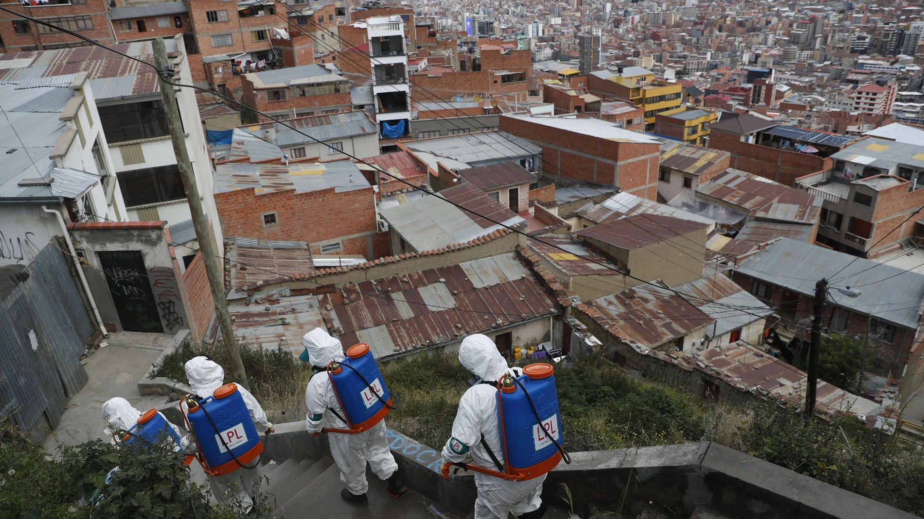 City workers disinfect a stairway in attempt to help contain the spread of the new coronavirus, in La Paz, Bolivia, Tuesday, April 28, 2020. (AP Photo/Juan Karita)