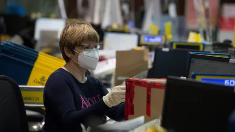 Varios funcionarios trabajando en la oficina de Correos de Cibeles (Madrid)