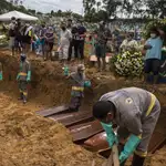 Varios sepultureros en un entierro colectivo en el cementerio Nossa Senhora Aparecida, en la ciudad de Manaos, estado Amazonas (Brasil)