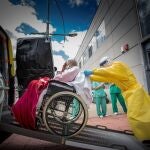Un auxiliar ayuda a subir a una ambulancia a un paciente que sale del Hospital de Aranda de Duero (Burgos). EFE/ Paco Santamaría