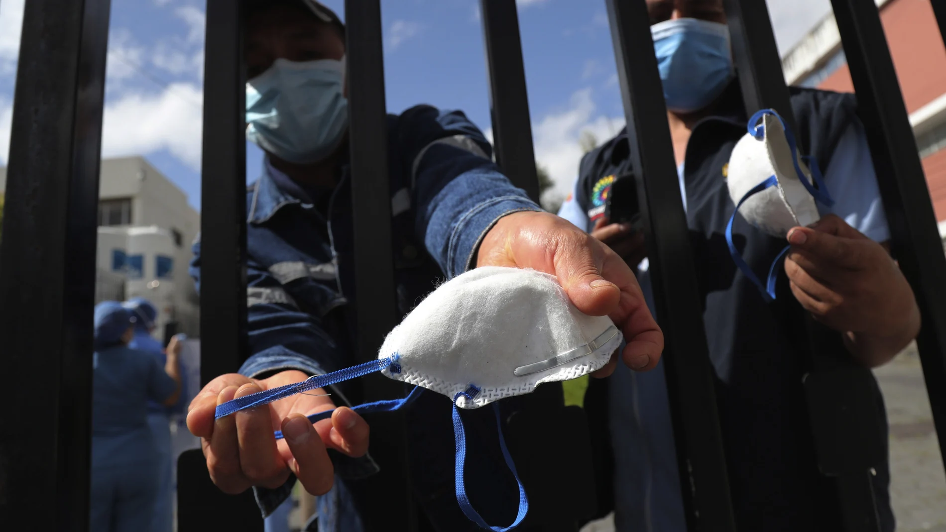Workers of the Eugenio Espejo hospital show worn out masks they use to work, during a protest to demand that the government deliver personal protection equipment, to be able to carry out their work safely during the new coronavirus pandemic, in Quito, Ecuador, Tuesday, April 28, 2020.The South American country has been hit hard by the pandemic, with the city of Guayaquil been hit especially hard. (AP Photo/Dolores Ochoa)