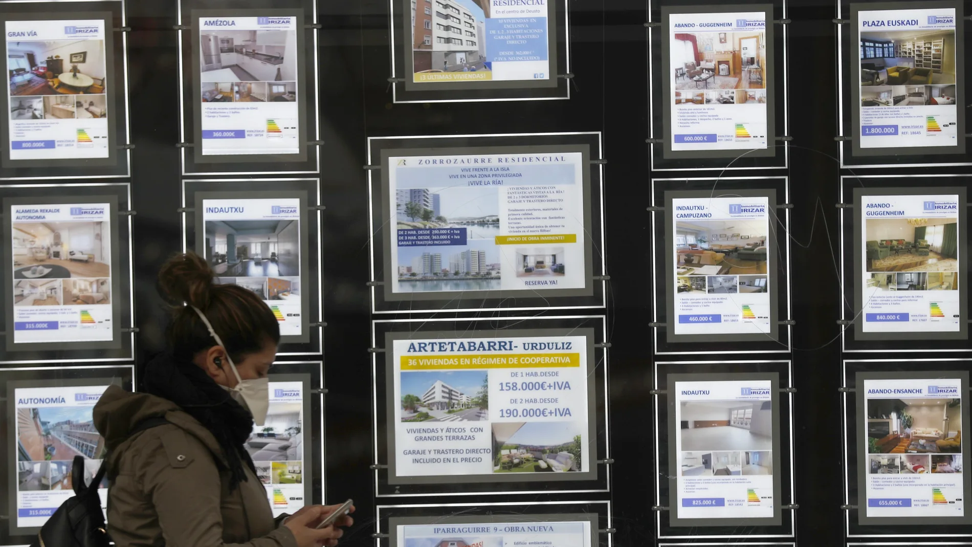 Una mujer pasa por delante de una inmobiliaria de venta y alquiler en Bilbao
