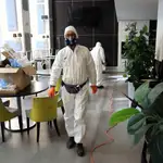 Trabajadores desinfectan un restaurante en Milán