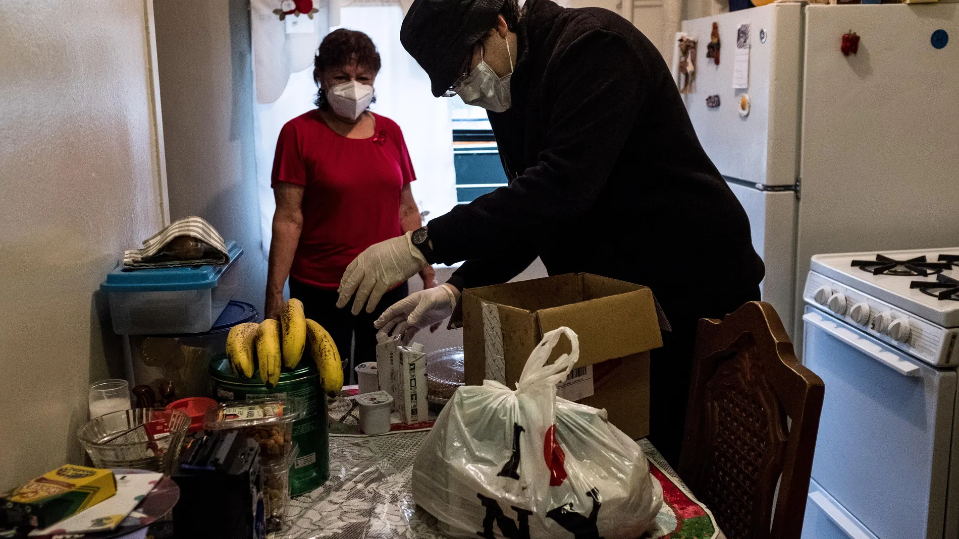 El padre Pedro Gonzalez lleva comida a Gloria, una salvadoreña de 75 años que reside en el Bronx