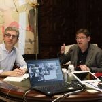 El presidente de la Generalitat, Ximo Puig (d), y el conseller de Política Territorial, Obras Pública y Movilidad, Arcadi España, durante la reunión por videoconferencia con personas expertas en distintas materias para abordar la situación de crisis originada por la pandemia de la Covid-19. Palau de la Generalitat.