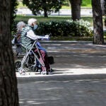 Dos ancianos con andadores sentados en un banco en el primer día en que los españoles pueden salir a pasear y hacer ejercicio al aire libre