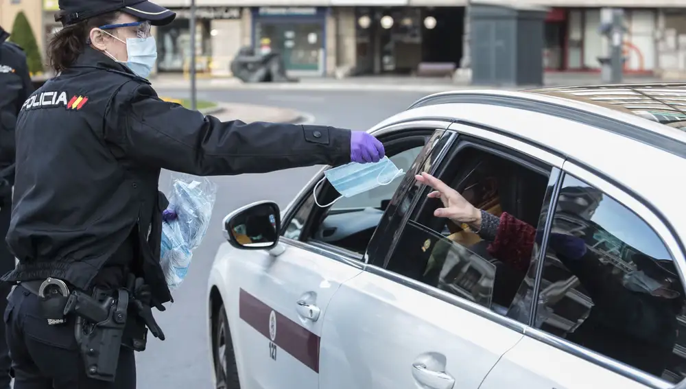 Miembros de Policía Local, Policía Nacional y Protección Civil de León, reparten mascarillas a usuarios del transporte público