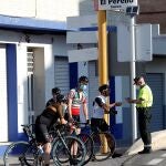 Un agente de la Guardia Civil junto a un grupo de ciclistas en el segundo día de la práctica de deporte individual durante el quincuagésimo día del estado de alarma