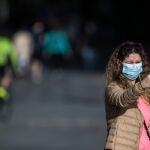 Una mujer con mascarilla se hace una foto con el móvil en el centro de Madrid
