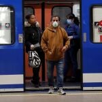 Viajeros con mascarilla saliendo de un vagón en la estación de Atocha