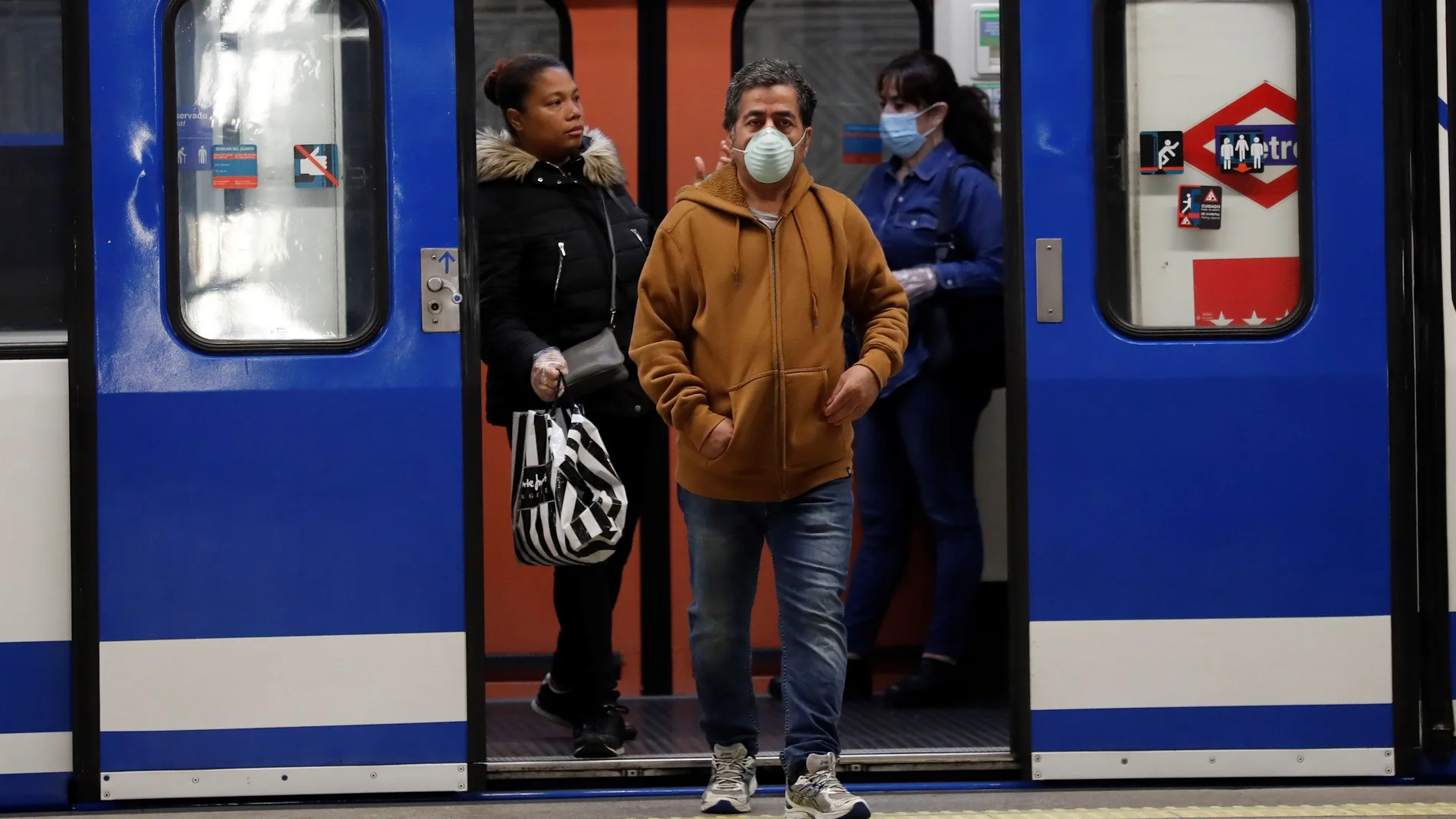 Viajeros con mascarilla saliendo de un vagón en la estación de Atocha