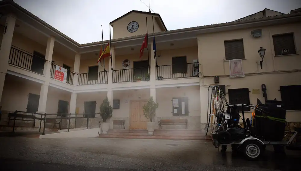 Una máquina de paramotor pulveriza desinfectante ante la fachada del Ayuntamiento de Brea de Tajo