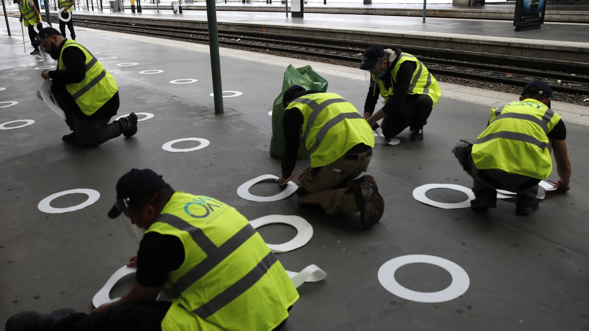Trabajadores colocan señales de plástico en el suelo de la estación de la Gare du Nord para mantener la distancia social