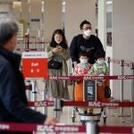 Una familia con mascarillas llega al aeropuerto al aeropuerto internacional de Seúl