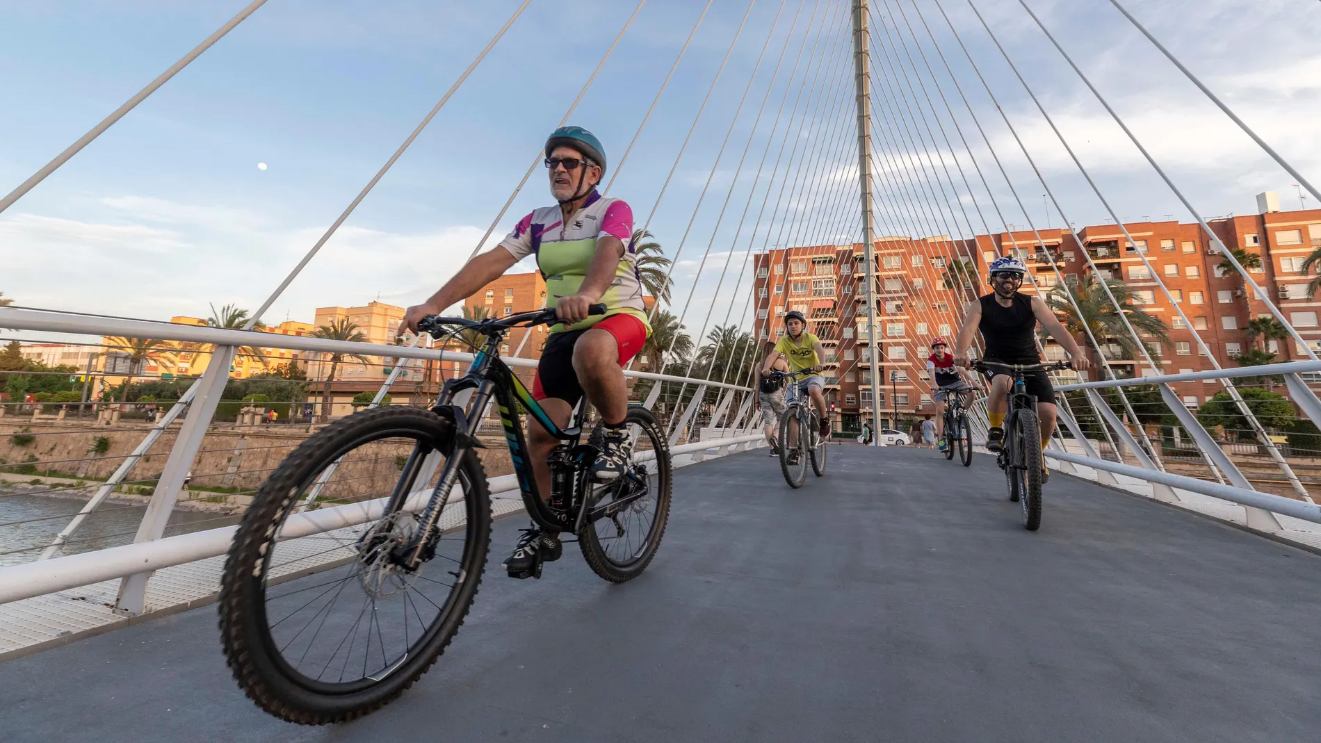 Varias personas montan en bicicleta en la pasarela Jorge Manrique de Murcia