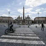 Viandantes pasean hoy por la plaza del Popolo de Roma