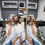 Una peluquera pone unas mechas a una clienta en un salón de Granada