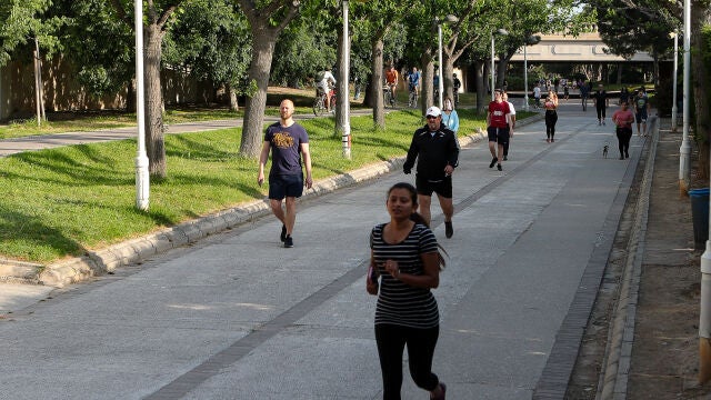 Transeúntes realizan ejercicio por el parque del Río Turia durante su franja horaria