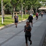 Transeúntes realizan ejercicio por el parque del Río Turia durante su franja horaria