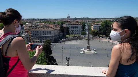 Dos chicas observan la ciudad de Roma desde el parque de Villa Borghese