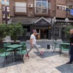 Los propietarios de un restaurante miden la distancia entre las mesas de la terraza
