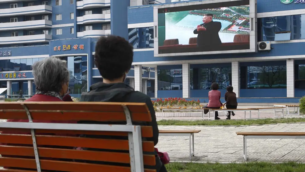 Norcoreanos en un parque de Pyongyang observan una pantalla gigante que muestra al líder norcoreano en la inauguración de una planta de fertilizantes este sabádo 2 de mayo