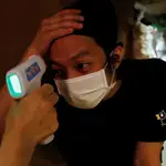Un empleado de un restaurante japonés se toma la temperatura