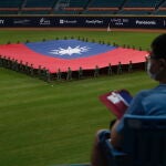 Soldados taiwaneses portan la bandera de Taiwán antes de un partido de béisbol en Nuevo Taipéi, al que asistieron mil personas