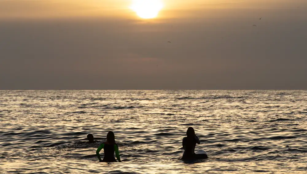 Varias personas hacen surf en la playa del Bogatell de Barcelona, una de las playas que a partir de hoy viernes los barceloneses pueden usar entre las 06.00 y las 10.00 horas para hacer deporte. EFE/Enric Fontcuberta