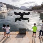 GRAF2948. CARTAGENA (MURCIA), 08/05/2020.- Una madre y sus hijos dan de comer a los peces en el puerto de Cartagena, en Murcia, en una jornada en la que se ha anunciado que la Comunidad de Murcia pasará a la fase 1 de la desescalada el próximo lunes 11 de mayo. EFE/Marcial Guillén