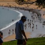 Una pareja camina junto a la playa de la Concha de San Sebastián, hoy sábado día 56 del confinamiento.