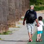 Un padre y su hijo regresan a casa a las 19:00 de la tarde, hora a la que termina el paseo de los más pequeños, en el paseo marítimo de los Lances en Tarifa, Cádiz,