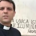 El sacerdote Julián Lozano junto a la pintada