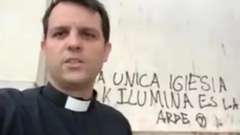 El sacerdote Julián Lozano junto a la pintada