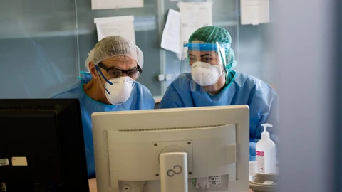 Dos médicos consultan información en la plataforma del sistema de salud español en marzo de 2020