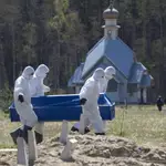 Un grupo de sepultureros, vestidos con material de protección, portan un ataúd con una víctima del Covid-19 en un cementerio en Kolpino, a las afueras de San Petersburgo